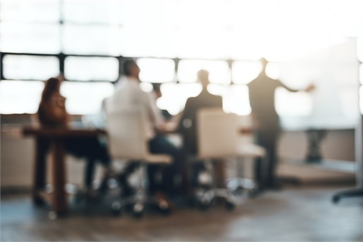 blurry image of people meeting in an office